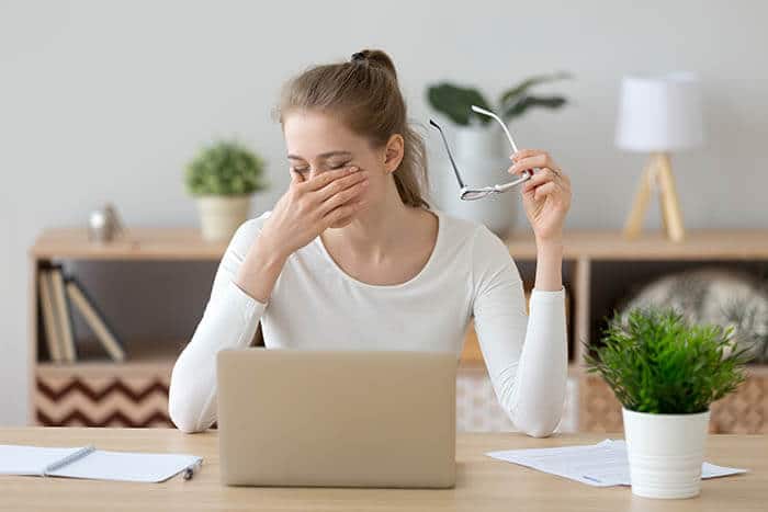 Woman Experiencing Eye Strain at Her Laptop Computer